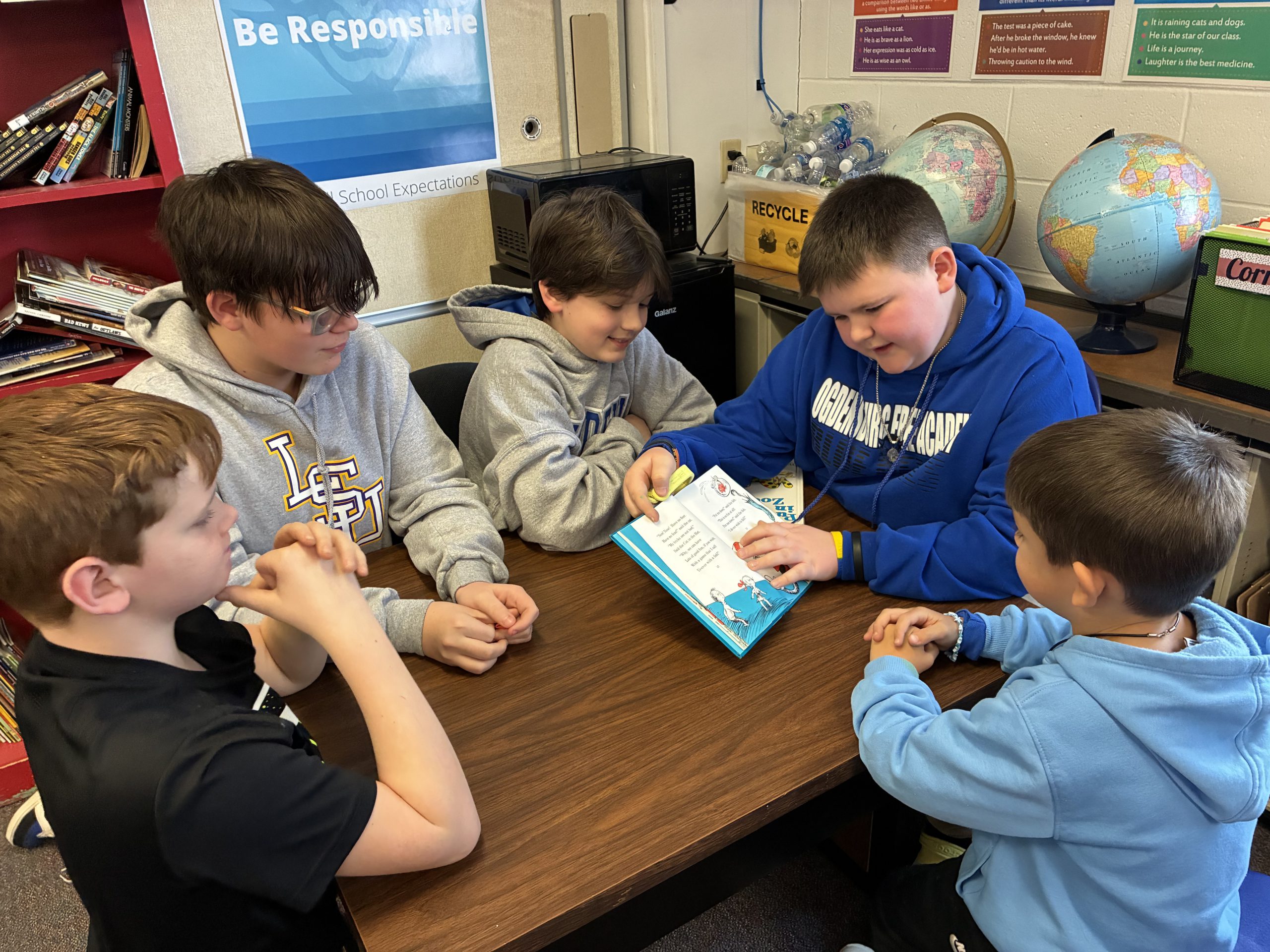 Young male students altogether reading a book