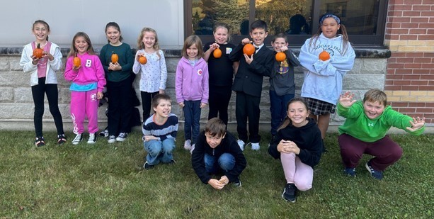 group photo of class holding pumpkins