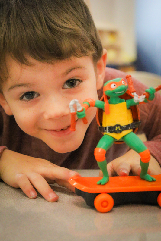 A student shows off his ninja turtle toy.
