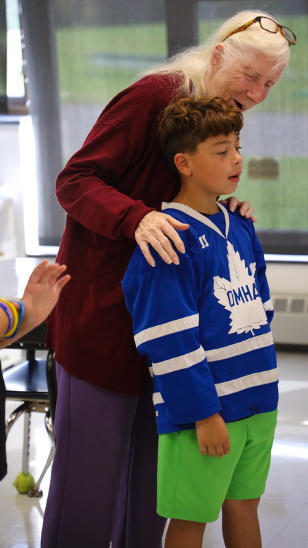 Judy Green applauds JFK Elementary student for solving a math problem.