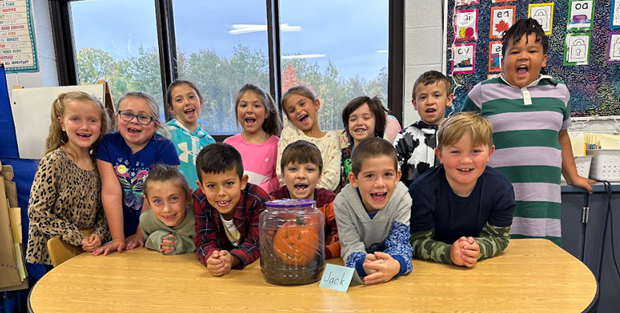 JFK class take group photo with pumpkin in a jar