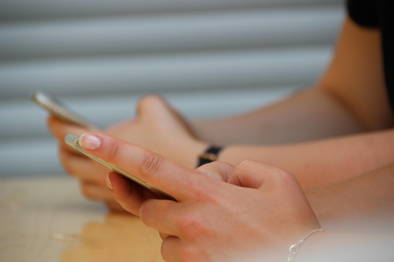 Closeup of hands holding a cell phone.