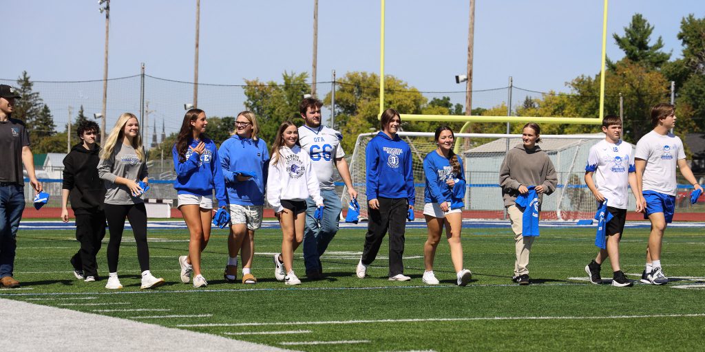 A group of OFA students walk across a field.
