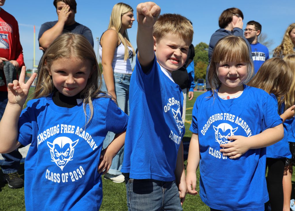 Three Madill elementary students pose in an outdoor setting.