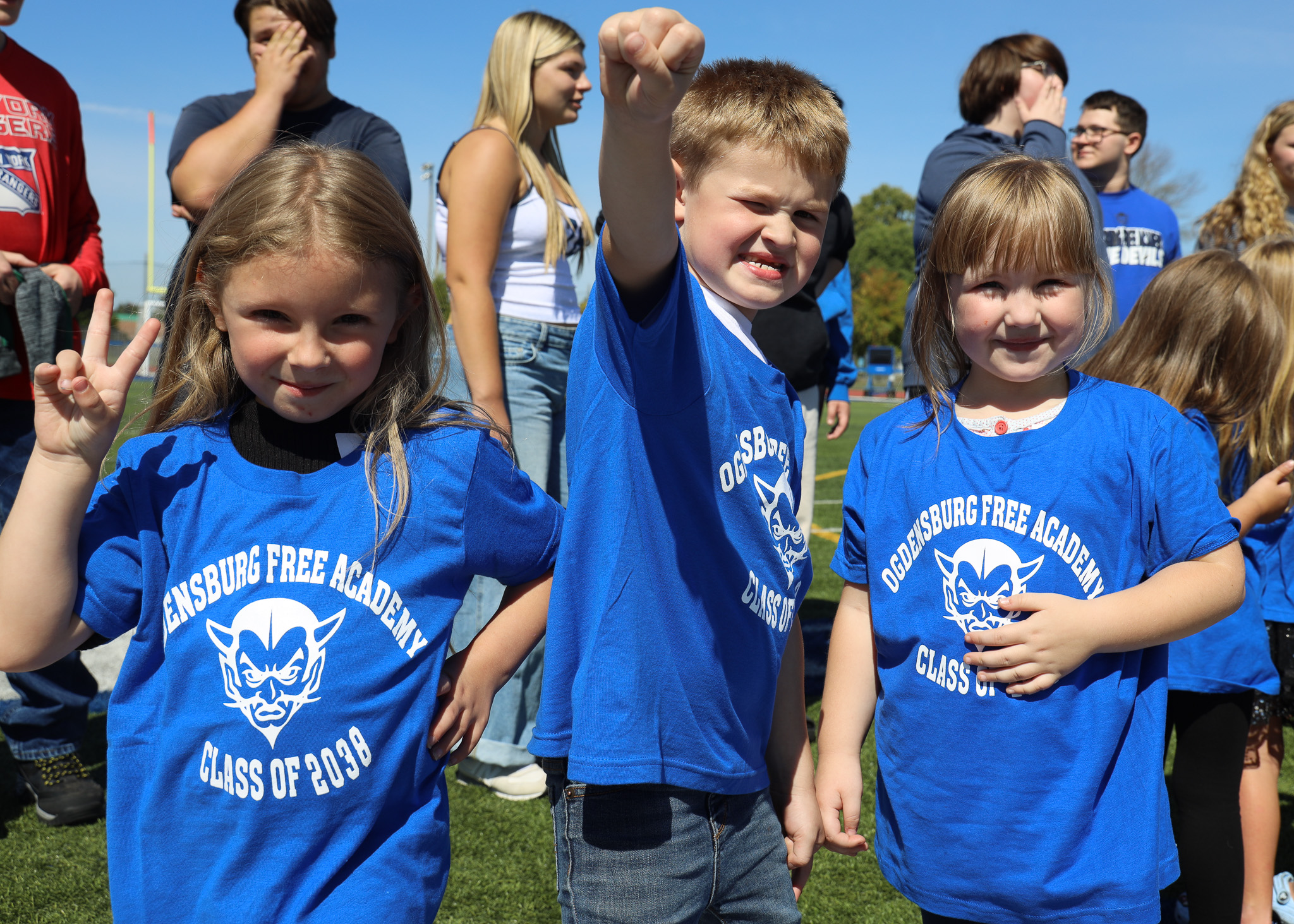 Three Madill elementary students pose in an outdoor setting.