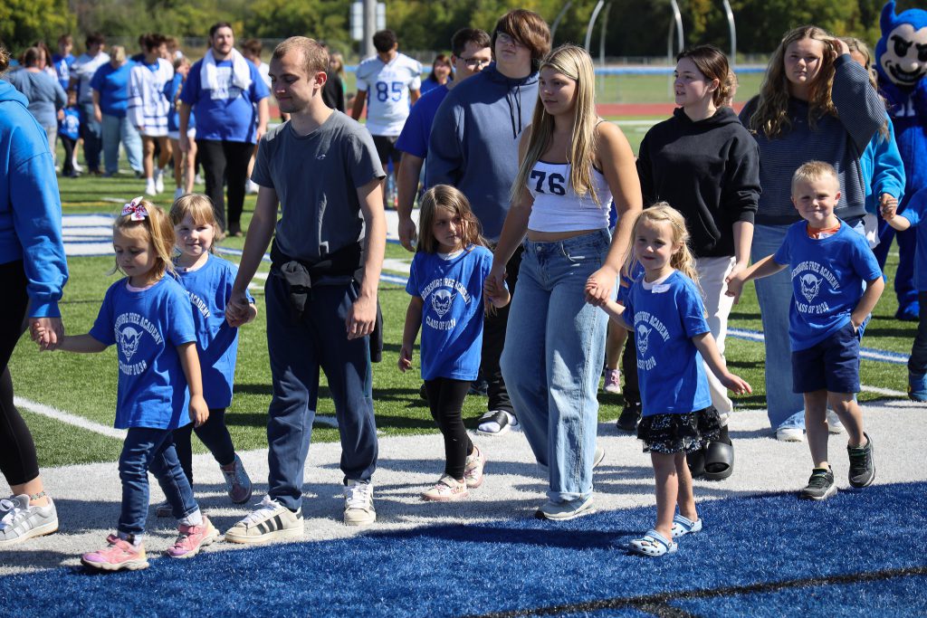 OFA students hold hands with kindergarteners.