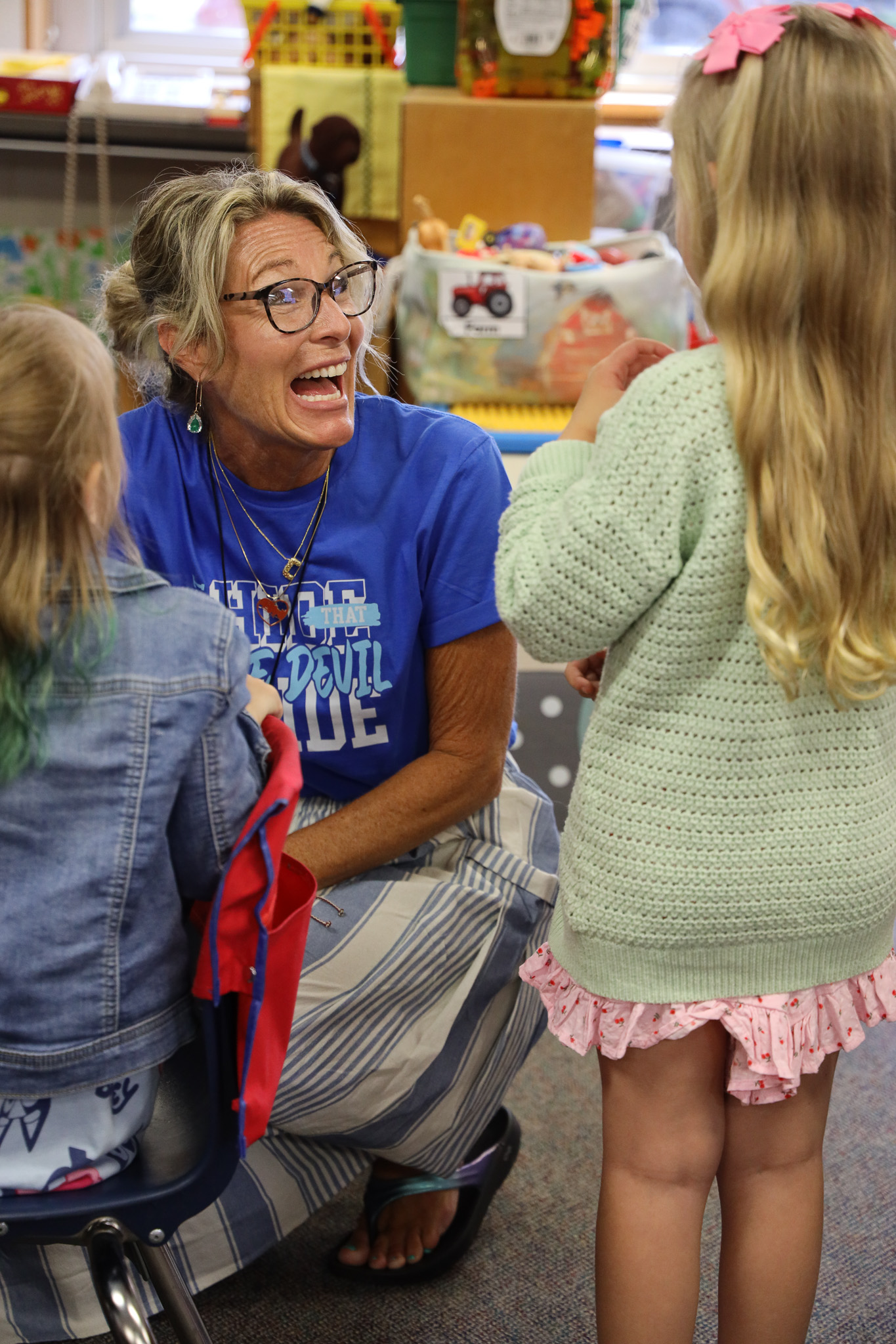 A teacher excitedly greeting a student.