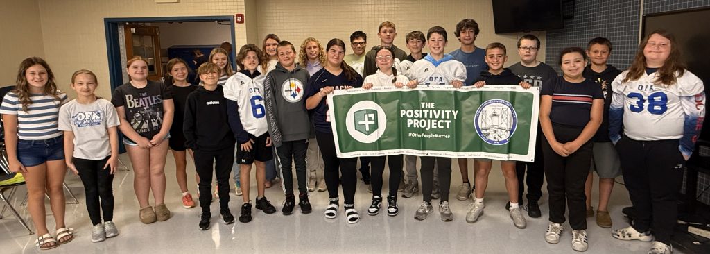 Collection of students holding a sign