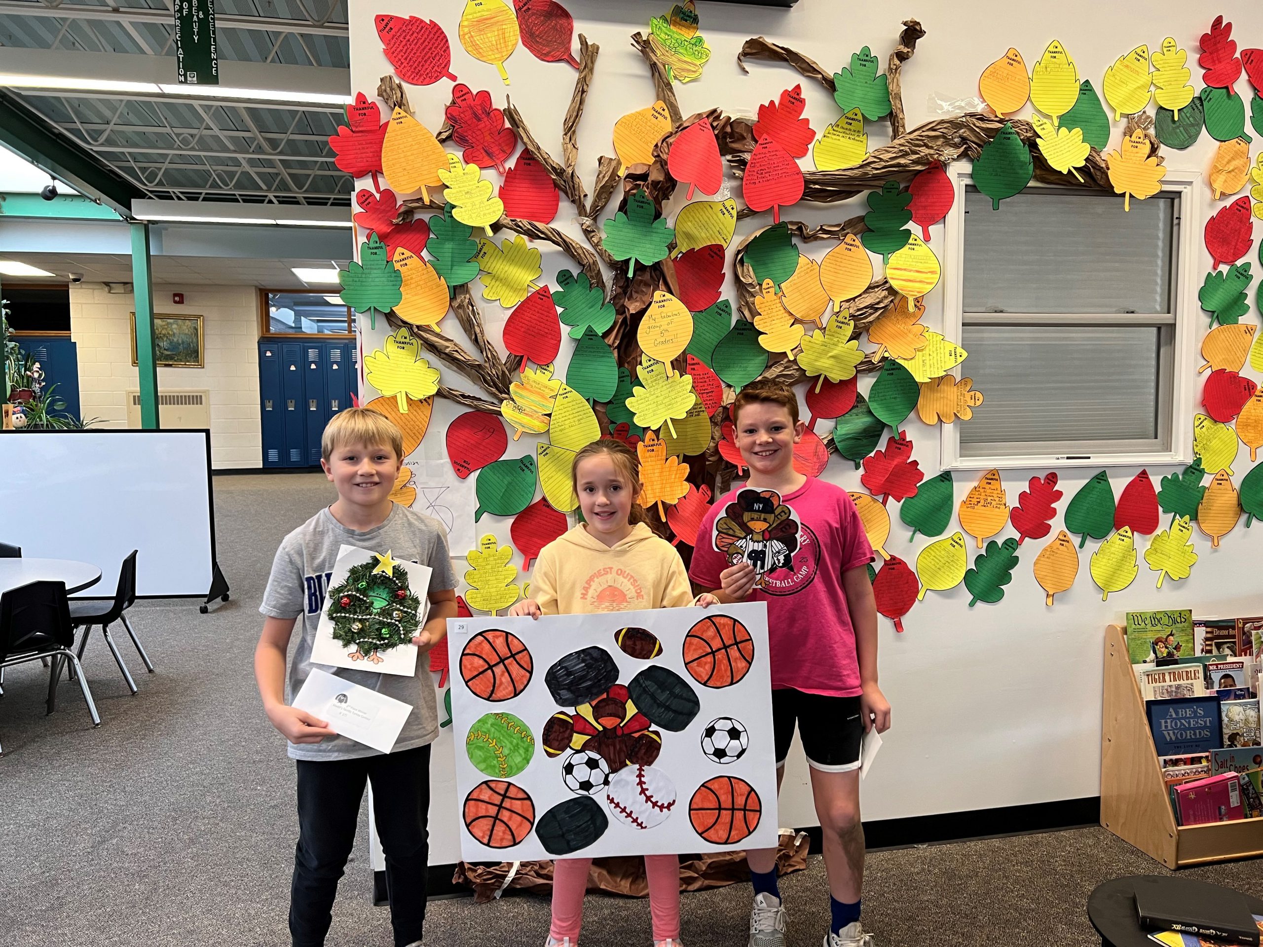 Elementary students holding their artwork