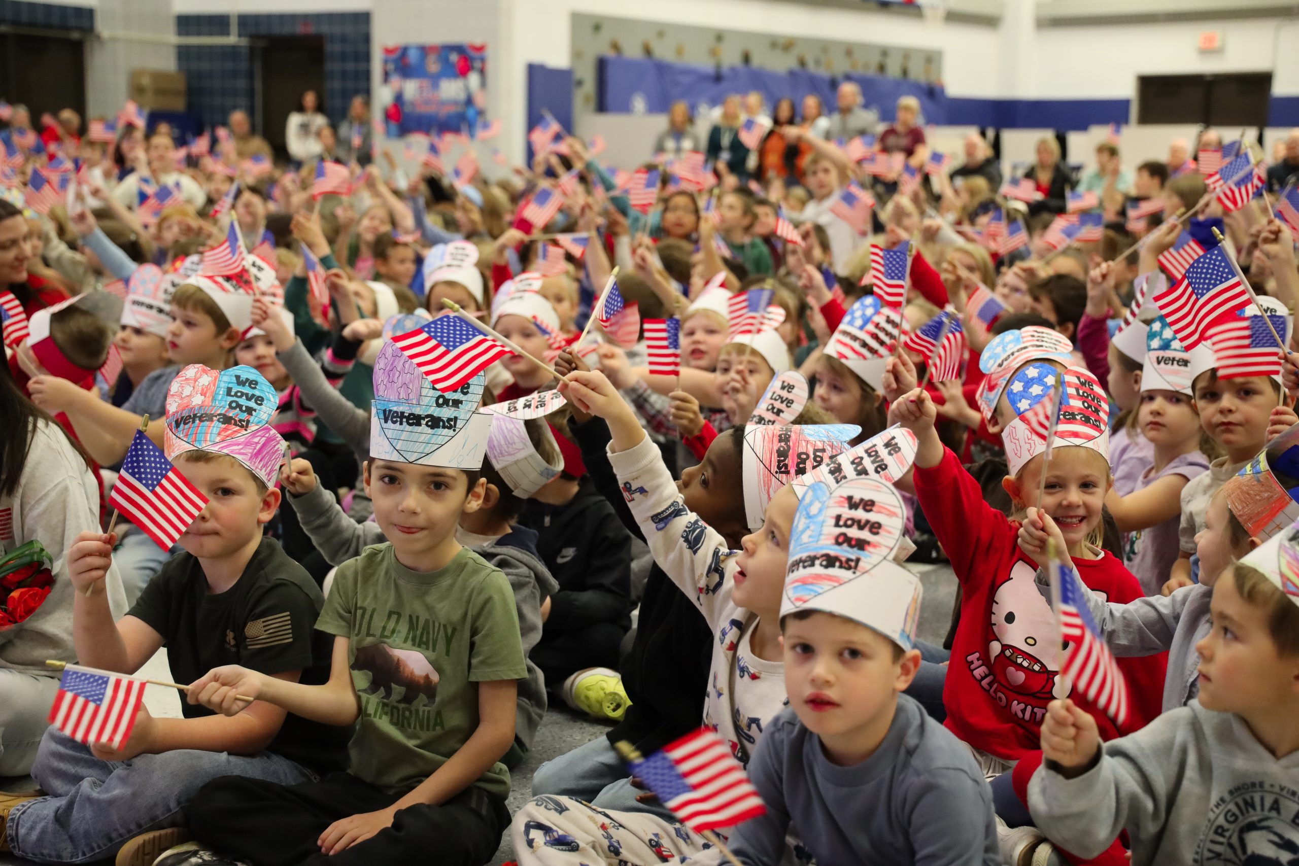 Students waving American flags during veterans day ceremony