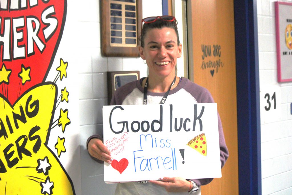 Amy Farrell holding a student-made sign