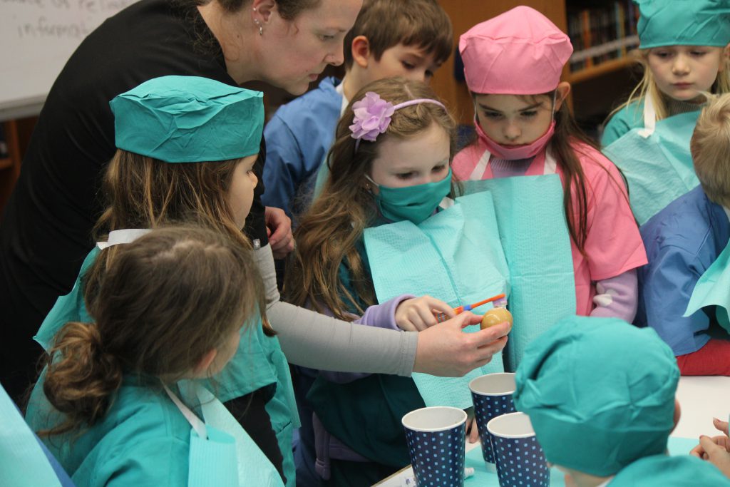 Female elementary student uses toothbrush