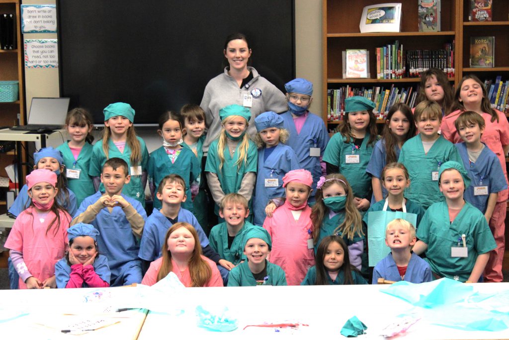 Group of elementary students with female hospital staff member