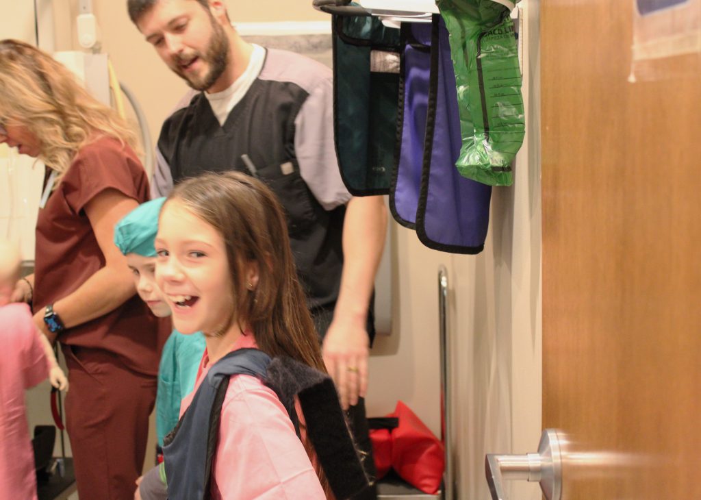 Female elementary student wears medical vest