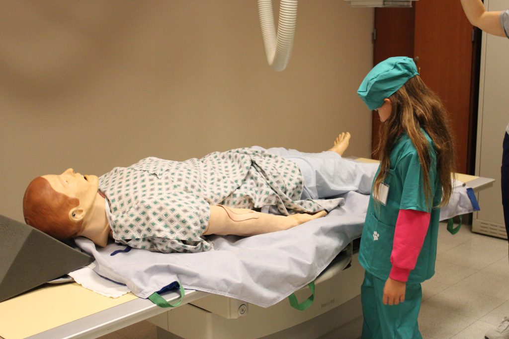 Female elementary student uses medical device