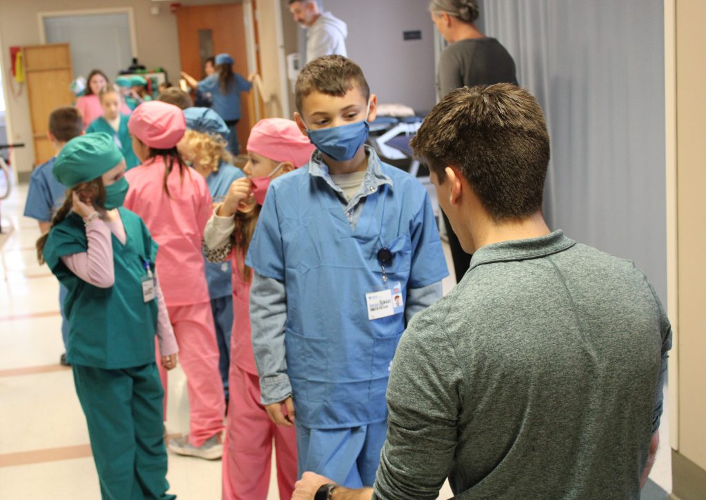 Male elementary student interacts with male hospital staff member