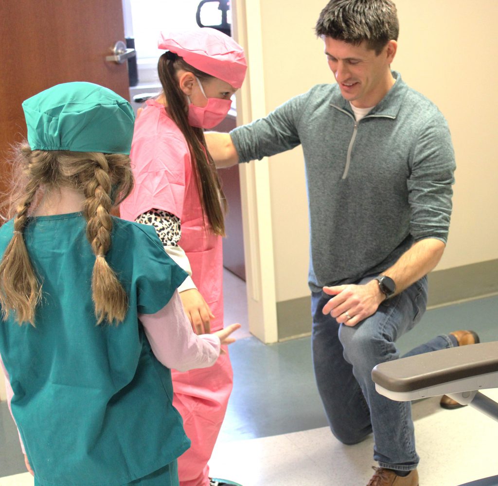 Female elementary student works on balance with male hospital staff member