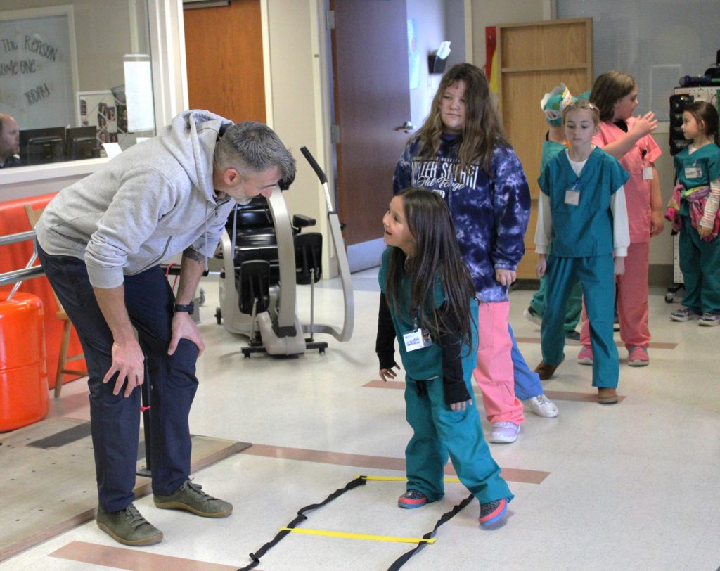 Female elementary student interacts with male hospital staff member