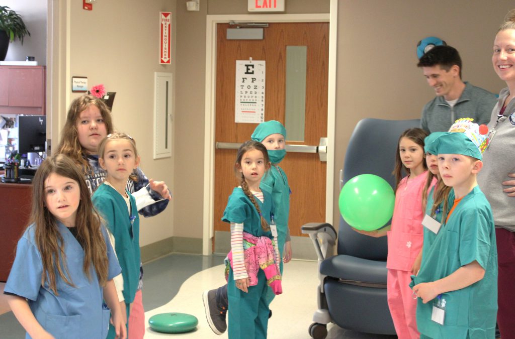 Group of elementary students with hospital staff members
