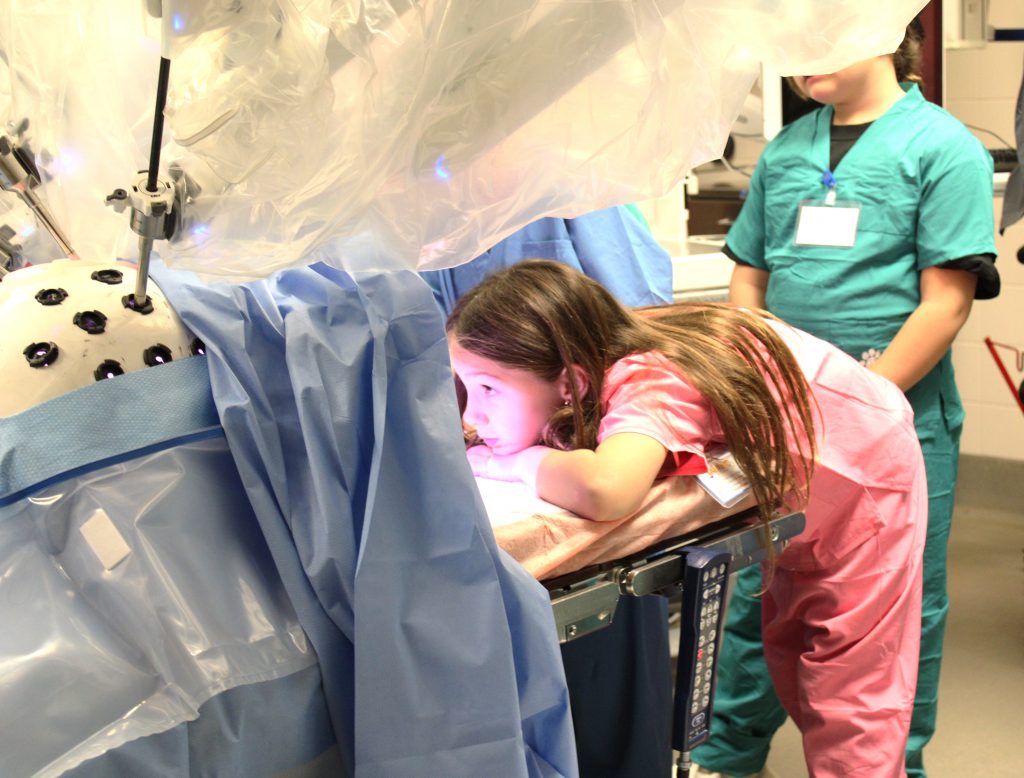 Female elementary student looking at medical device