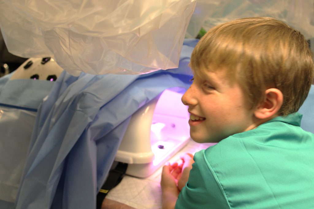 Male elementary student looking at medical device