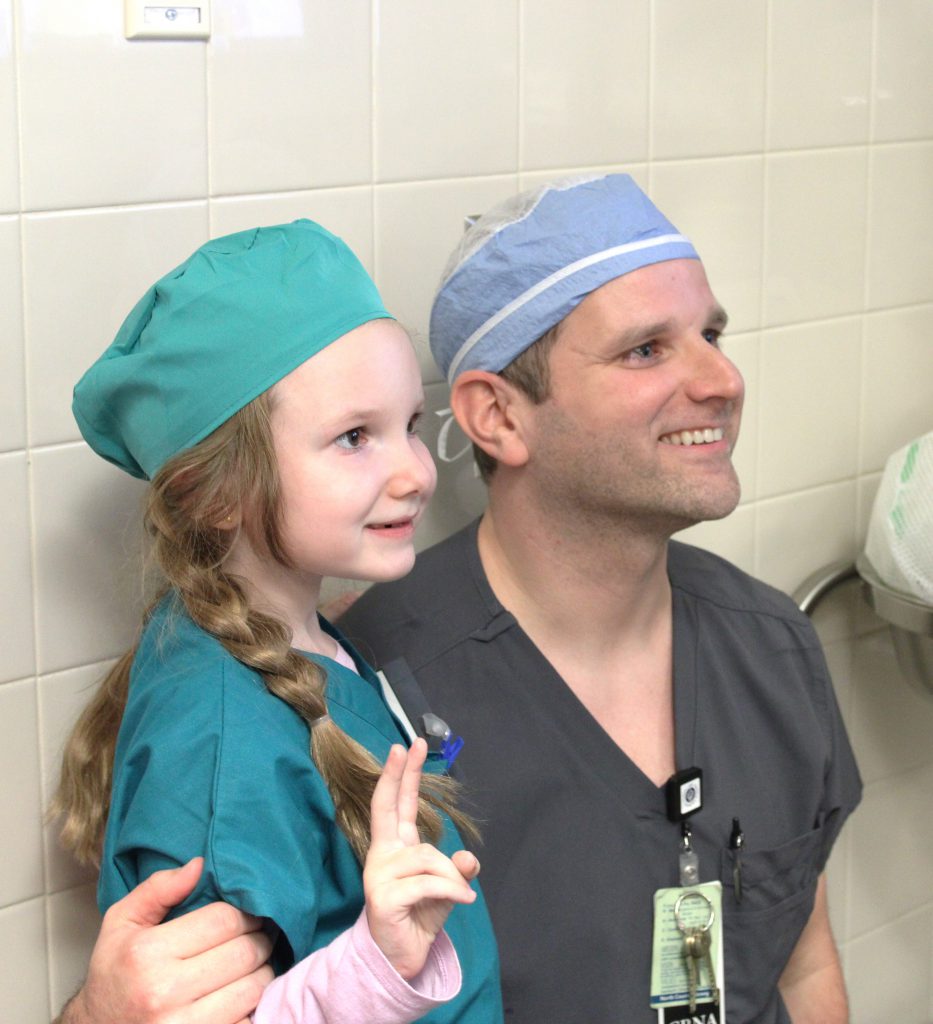 Female elementary student with a male hospital staff member that is her dad