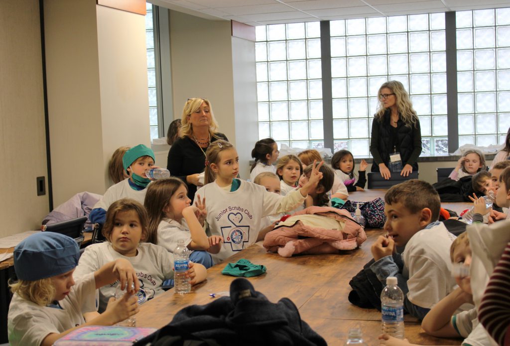 Elementary students and elementary teachers gathered around a table