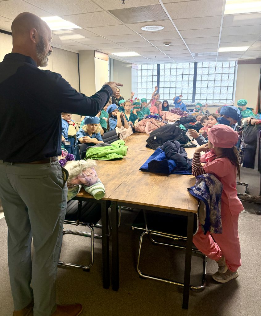 Elementary students listening to hospital staff member