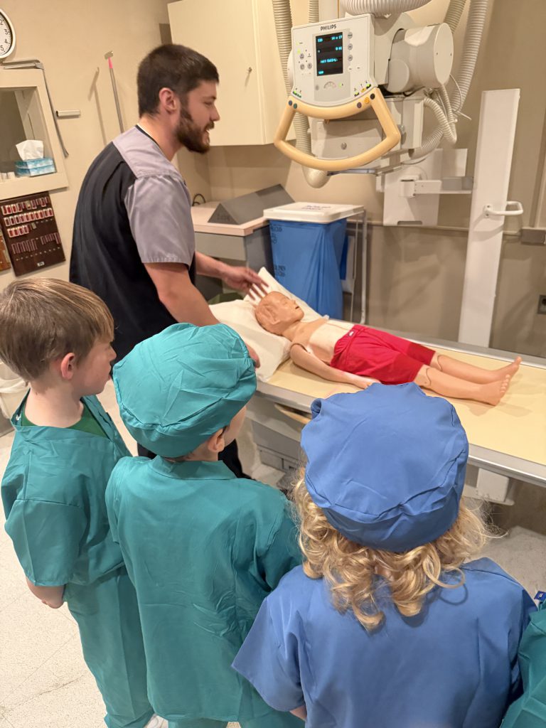 Elementary students listening to hospital staff member
