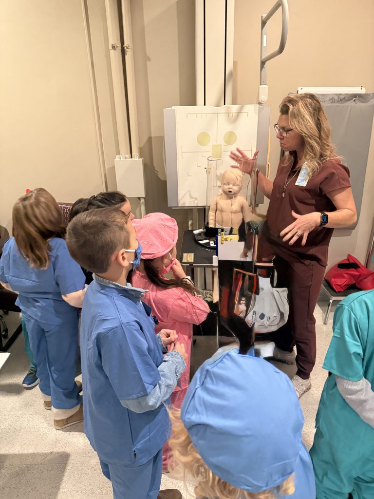 Elementary students listening to hospital staff member