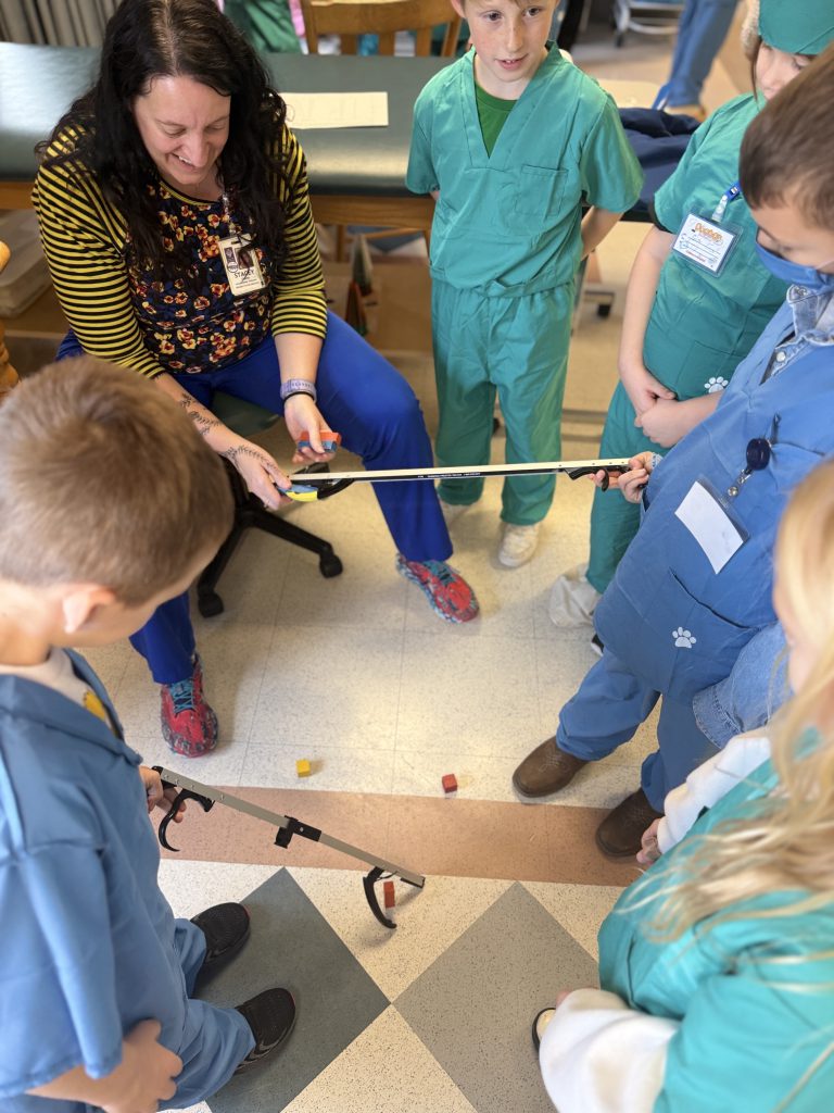 Elementary students participate in activity with hospital staff member