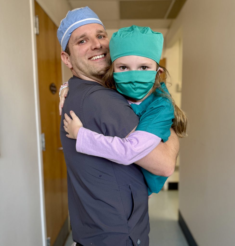 Female elementary student with a hospital staff member who is her dad