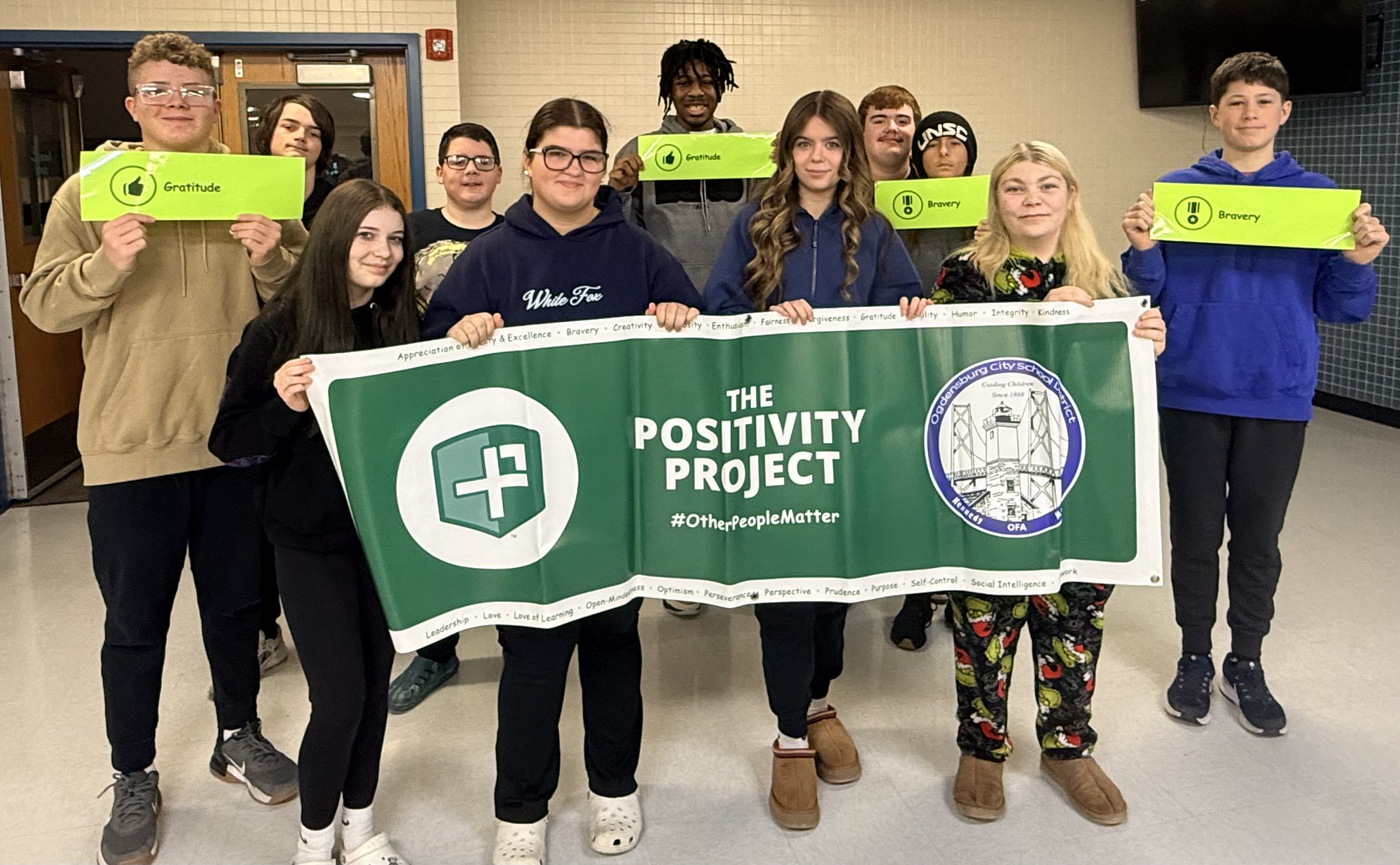 Large group of teenage students holding signs