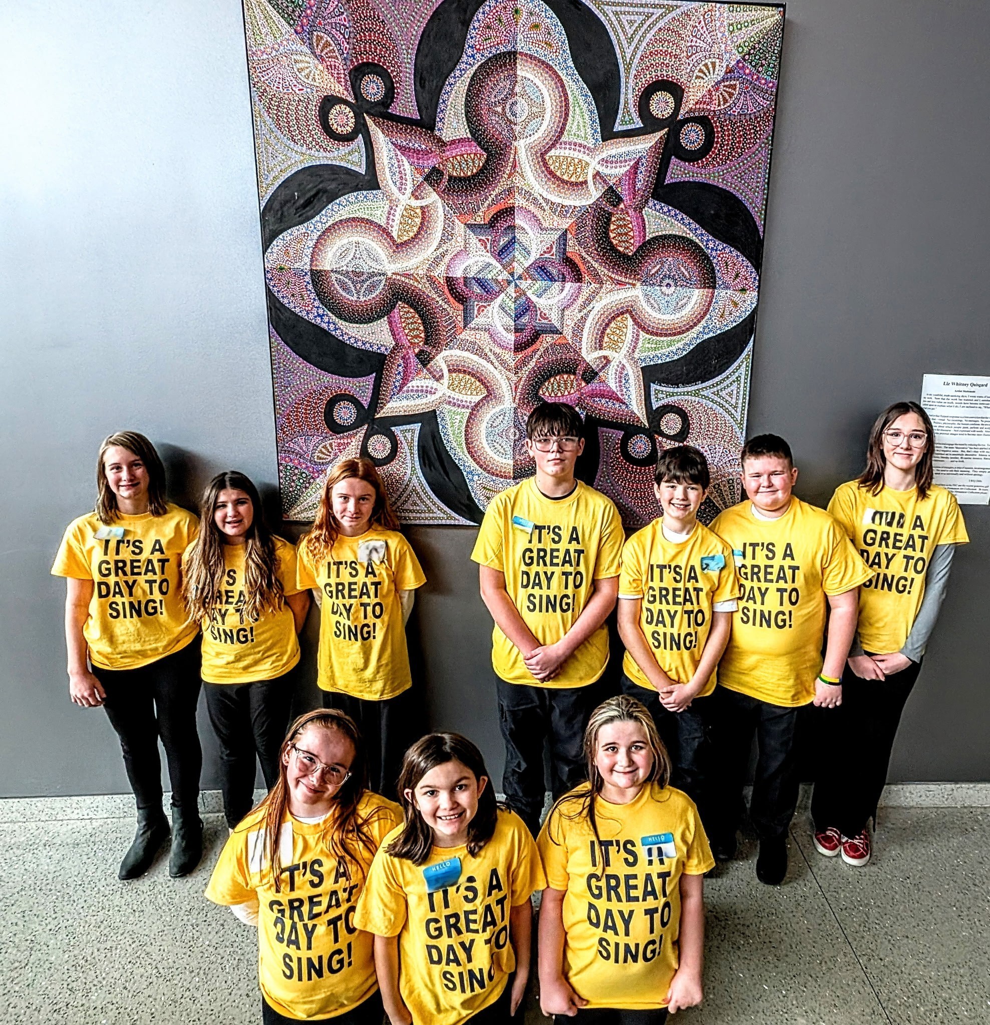 Small group of elementary students smiling wearing yellow