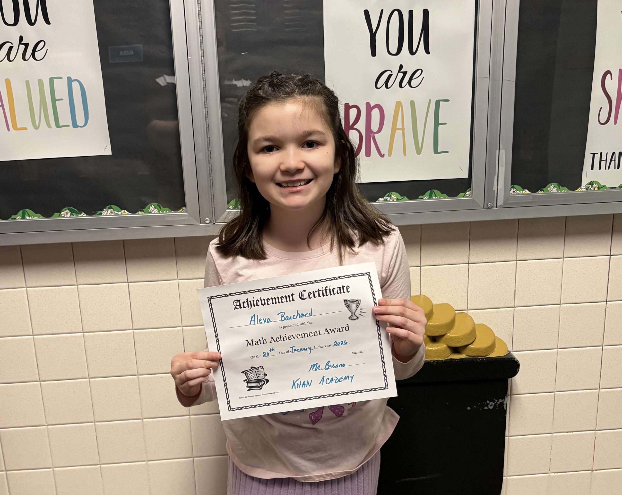 Female elementary student smiling with a certificate