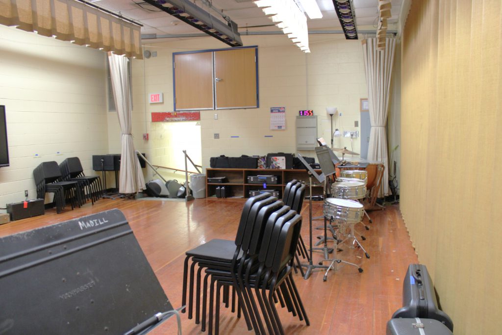 Music room with stacks of chairs and instruments
