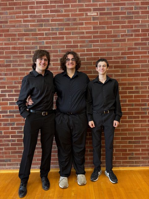 Small group of male high school students wearing black with smiles