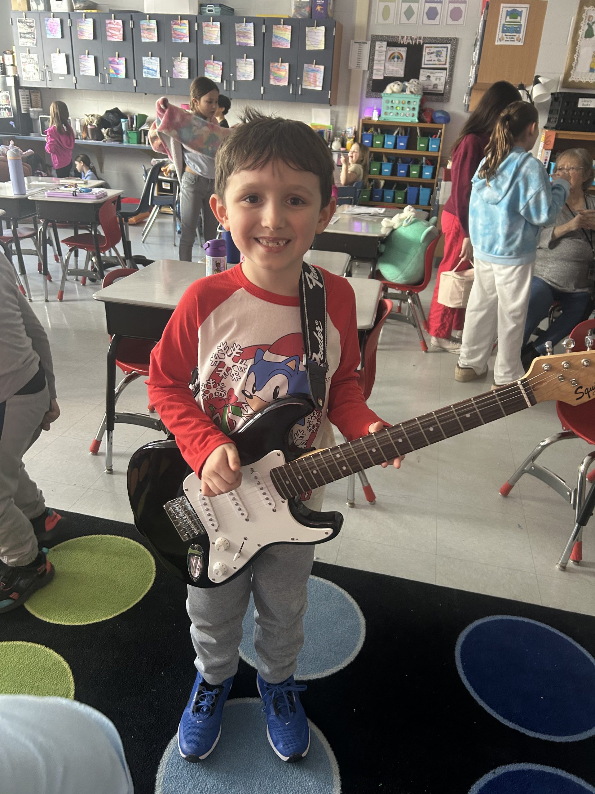 Young male elementary student holding a guitar