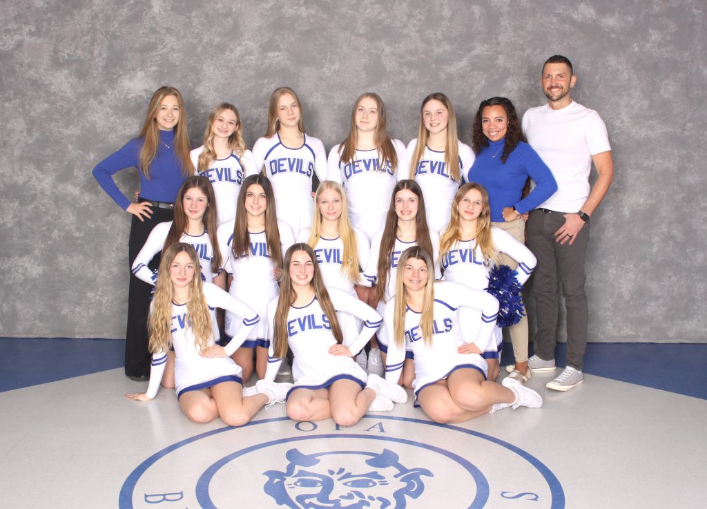 Small group of female high school cheerleaders with female and male coaches