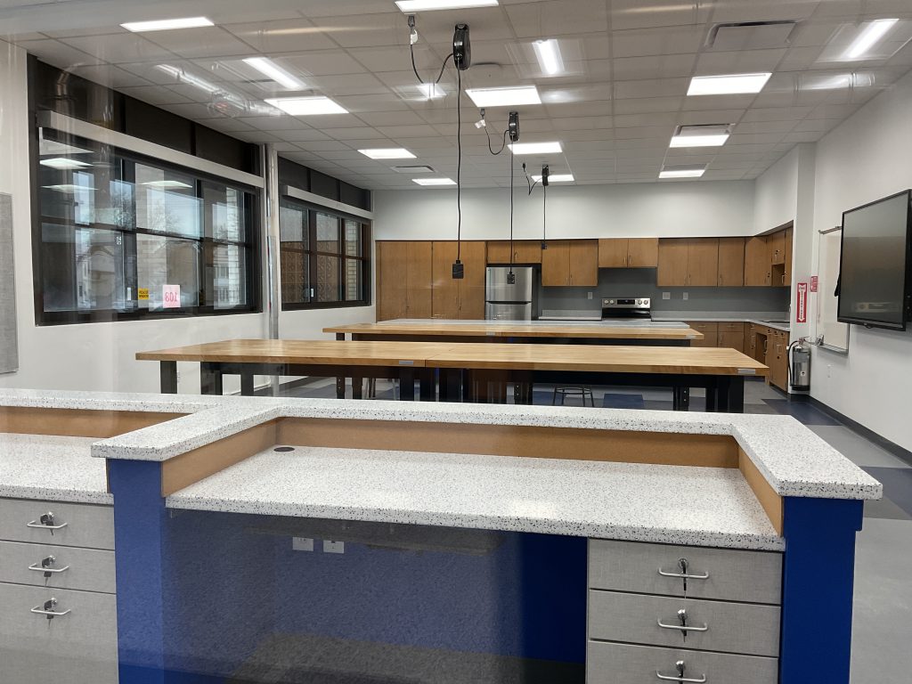 Empty classroom with two large wooden tables and a marbled desk space