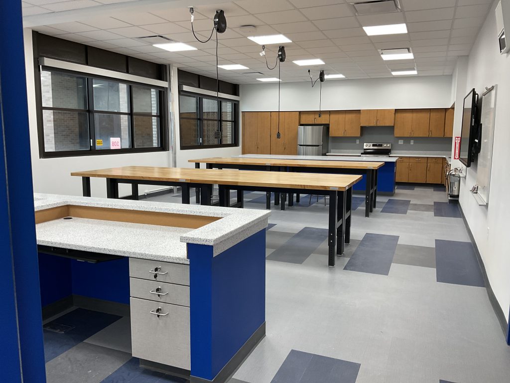 Empty classroom with two wooden desks and a marbled desk