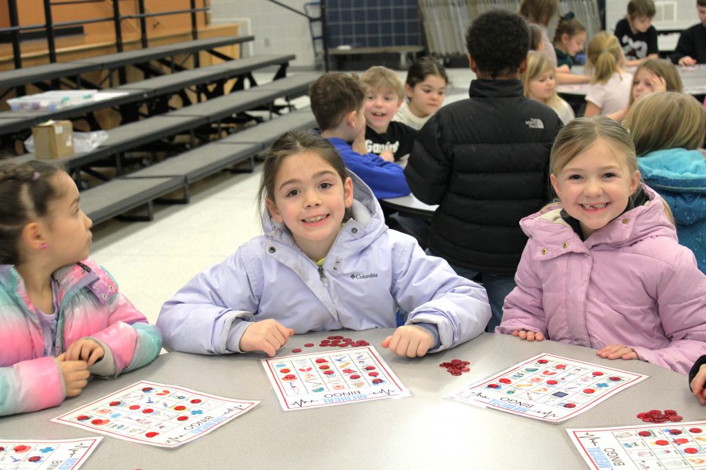 Female elementary students smiling and playing BINGO