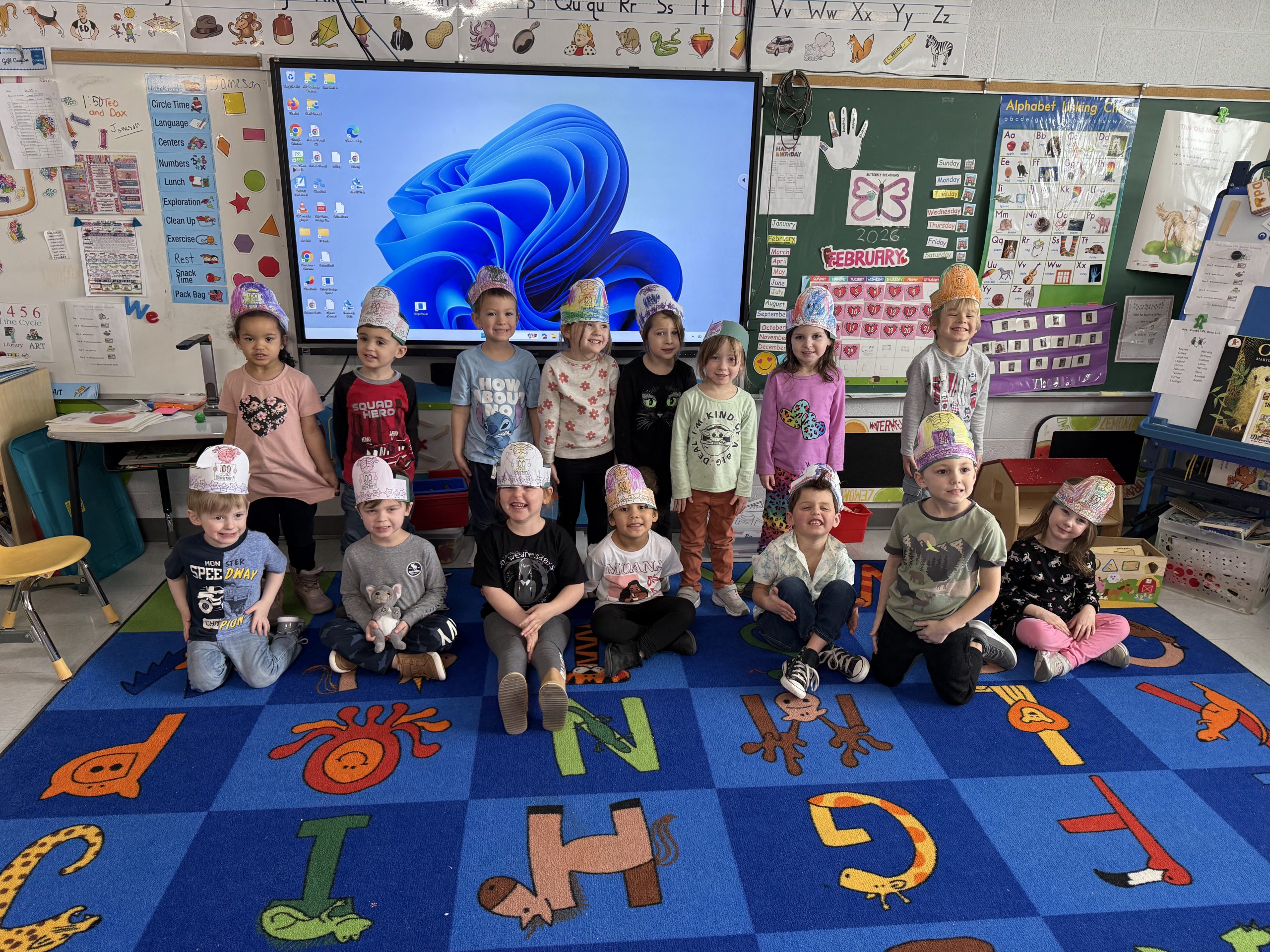 Small group of elementary students smiling and wearing hats