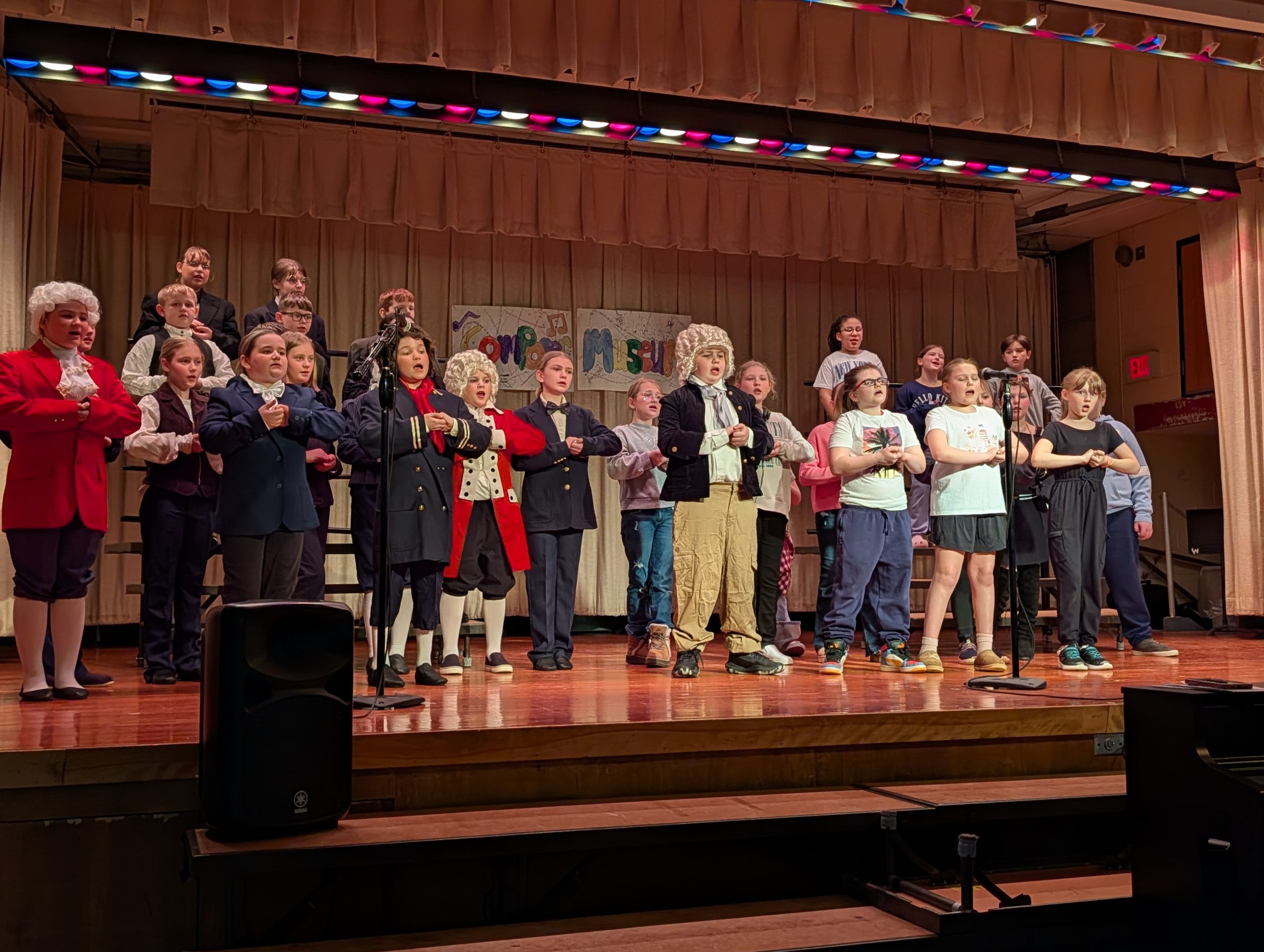 Small group of young students dressed in costumes performing on stage