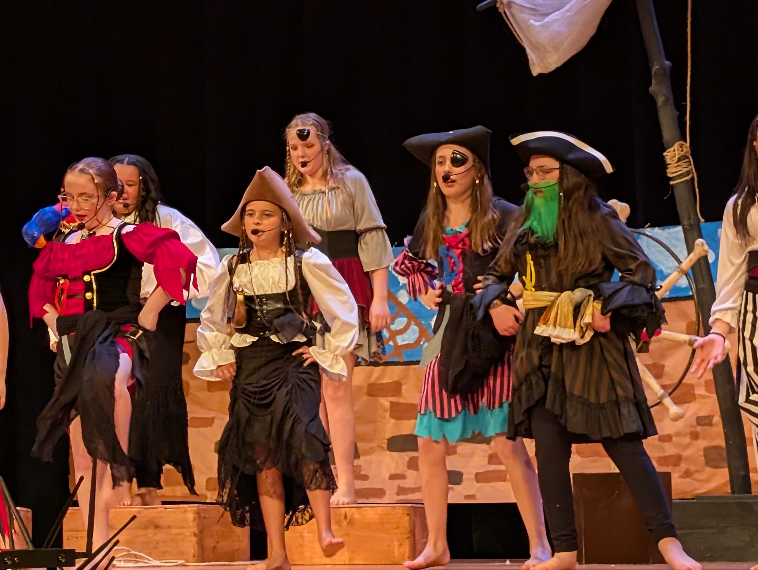 Small group of young students in costumes performing on stage