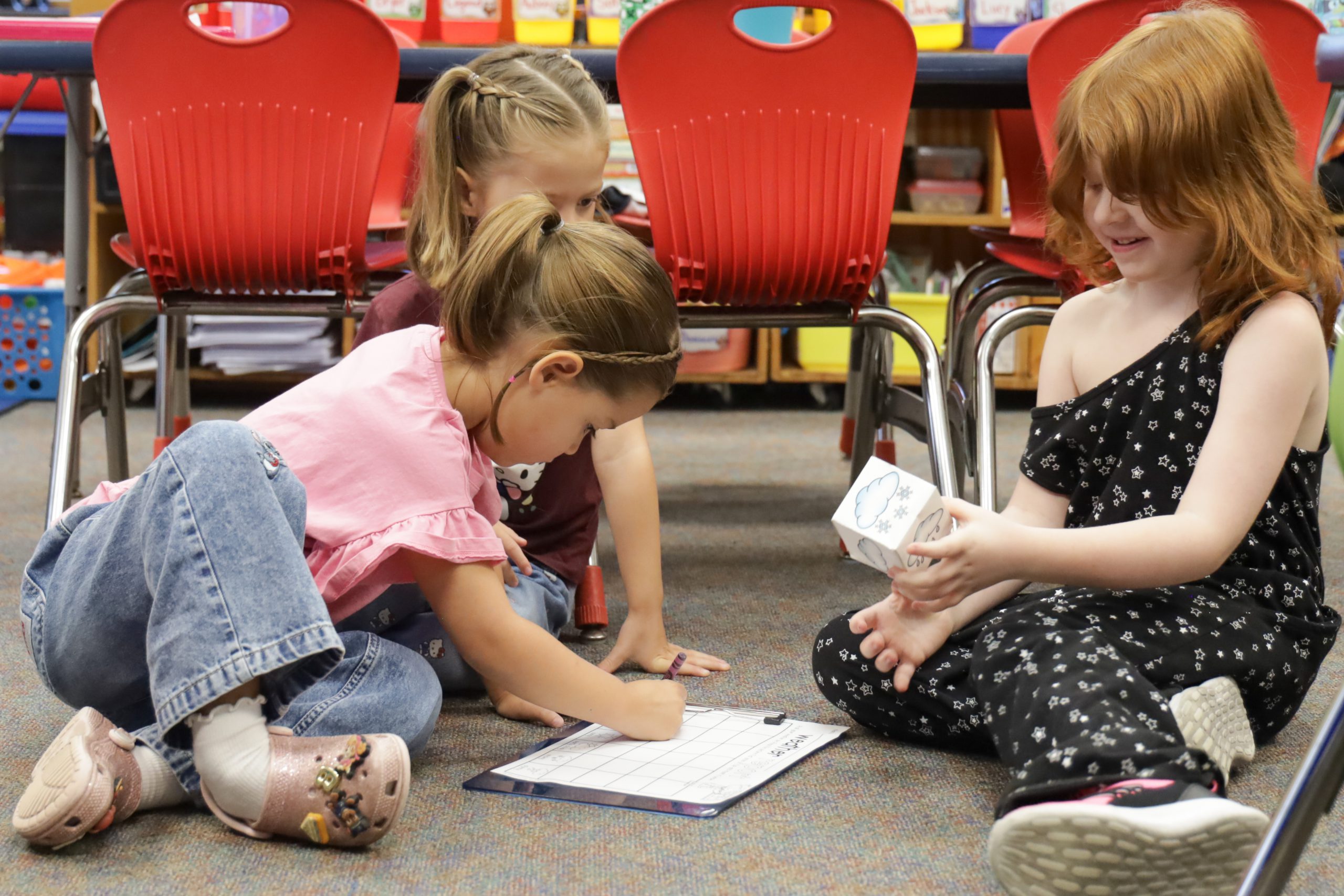 students working on the floor in classroom