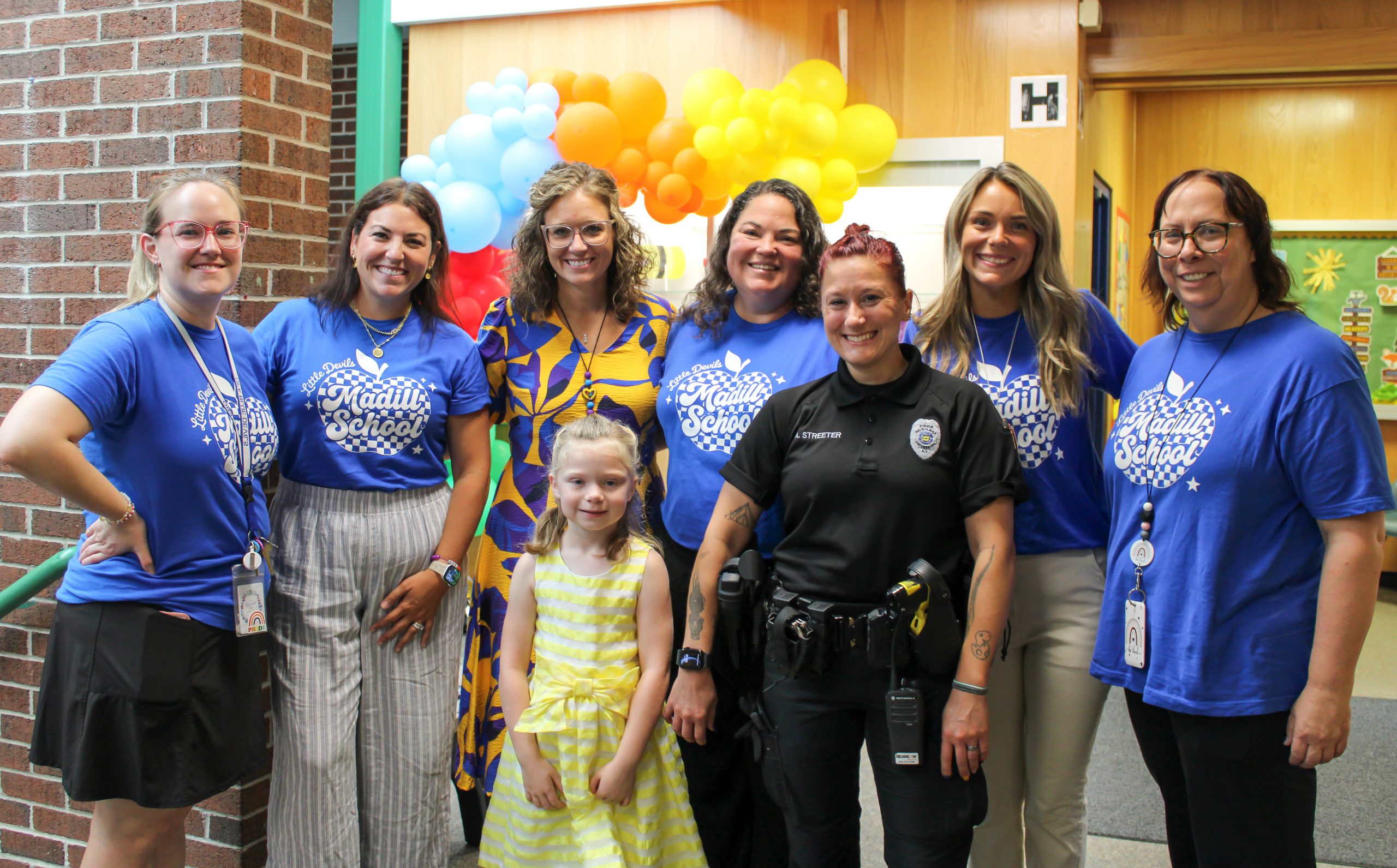 teachers, student resource officer and a student smiling